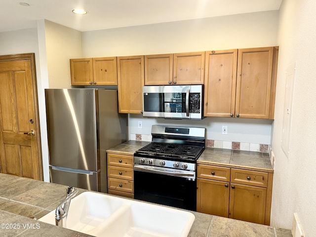 240 Chapel Pl Unit Br-309, Avon, CO 81620 - kitchen with appliances with stainless steel finishes, brown cabinets, recessed lighting, and tile counters
