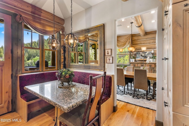 1416 Red Draw, Edwards, CO 81632 - dining area featuring a chandelier, plenty of natural light, wood finished floors, log walls, and beam ceiling