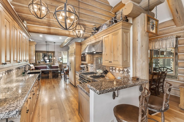 1416 Red Draw, Edwards, CO 81632 - kitchen with wall chimney exhaust hood, a chandelier, light wood-style floors, backsplash, and beamed ceiling