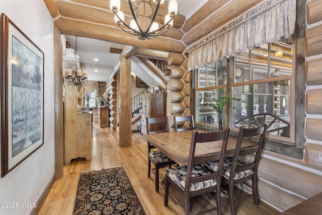 1416 Red Draw, Edwards, CO 81632 - dining room with a chandelier, log walls, and hardwood / wood-style floors