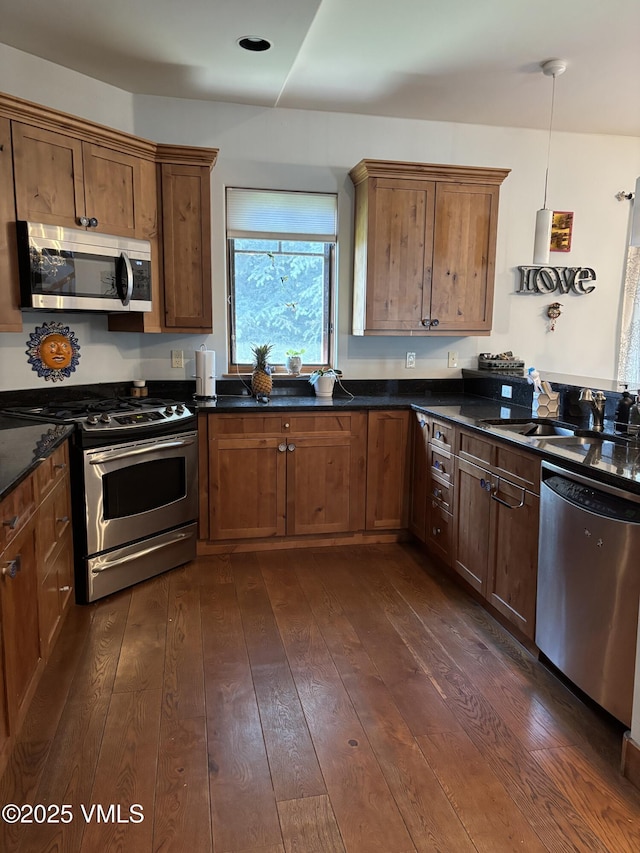 40 Bunker Way, Eagle, CO 81631 - kitchen featuring stainless steel appliances, dark countertops, dark wood-style floors, and brown cabinets