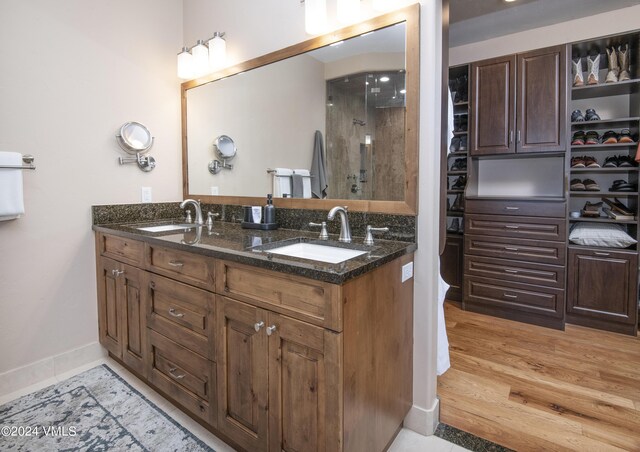 bathroom featuring vanity, wood-type flooring, and a shower