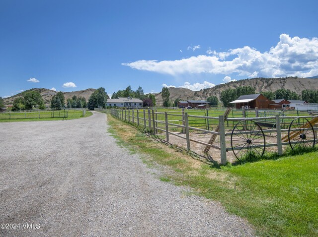 view of street with a rural view and a mountain view