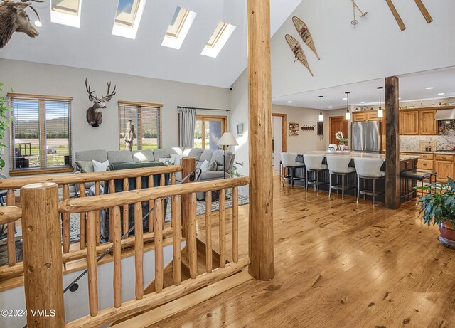 living room with high vaulted ceiling and light wood-type flooring