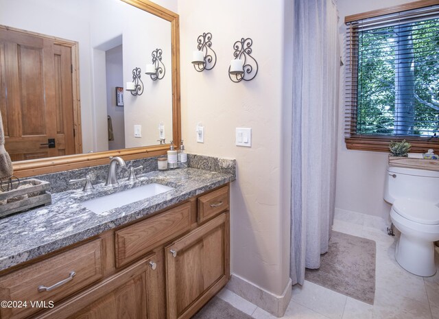 bathroom with vanity, toilet, and tile patterned flooring