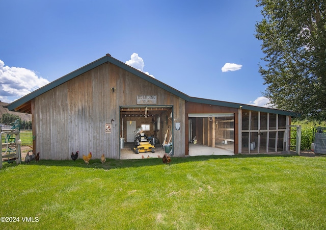 back of property featuring an outdoor structure and a yard