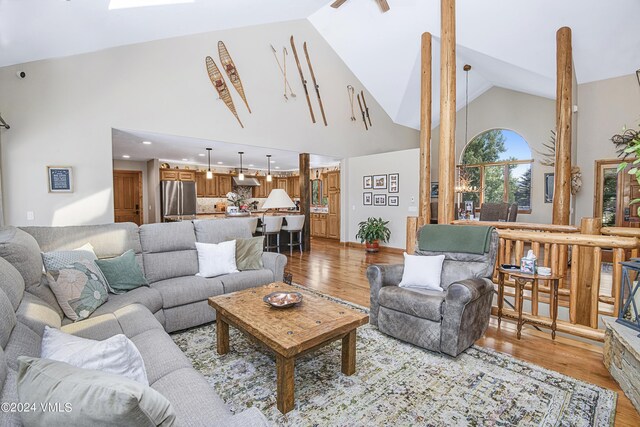 living room featuring high vaulted ceiling and light hardwood / wood-style floors