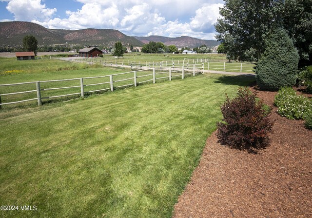 view of yard with a rural view and a mountain view