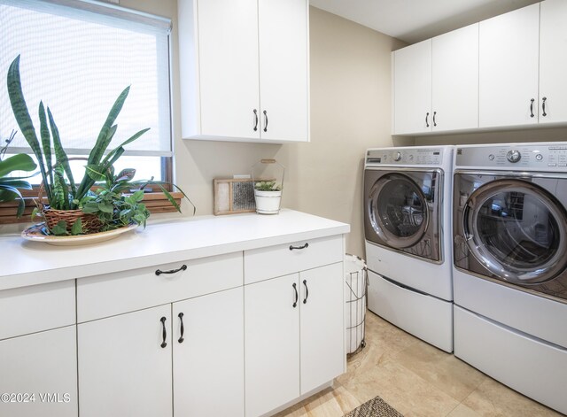 washroom featuring cabinets and separate washer and dryer