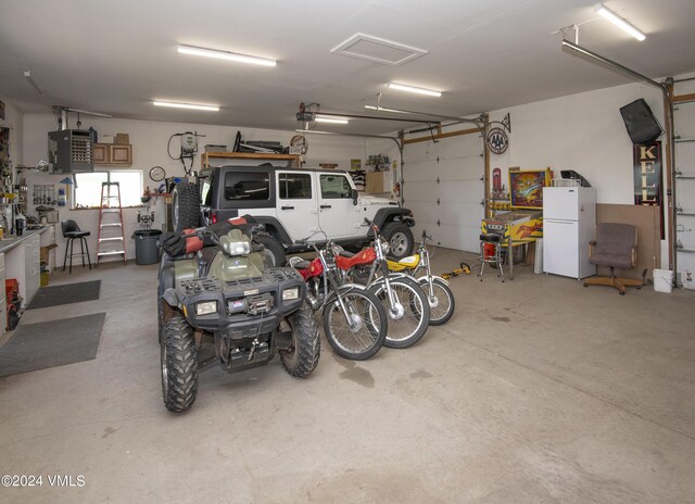 garage with a garage door opener and white refrigerator