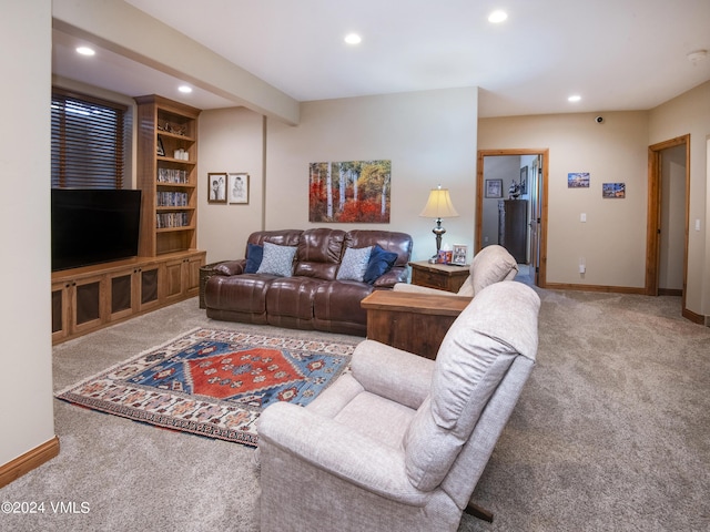 carpeted living room featuring beam ceiling