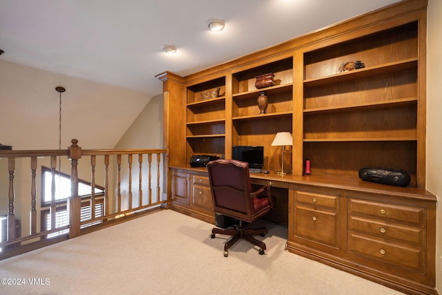 office area with vaulted ceiling, built in desk, and carpet floors