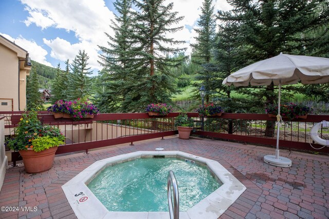 view of pool featuring an in ground hot tub, a patio, and fence