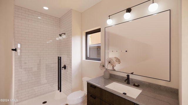 bathroom featuring a tile shower, vanity, and toilet