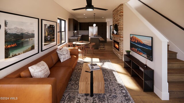 living room with hardwood / wood-style floors, a stone fireplace, and ceiling fan