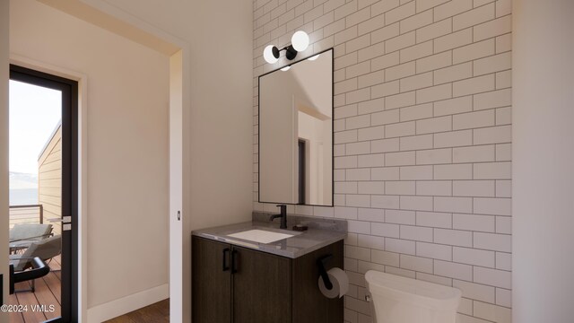 bathroom featuring a healthy amount of sunlight, vanity, toilet, and tile walls