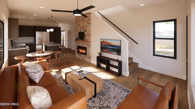 living room featuring a stone fireplace, sink, ceiling fan, and light hardwood / wood-style flooring