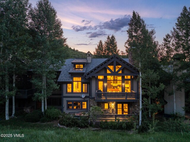 352 Cresta Rd, Edwards, CO 81632 - rear view of house with a balcony, stone siding, and a chimney