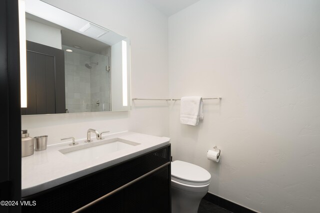 bathroom with toilet, walk in shower, and vanity