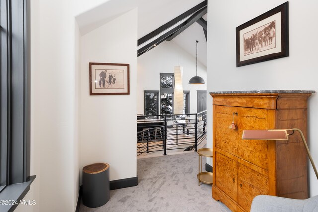 hallway featuring carpet floors, lofted ceiling with beams, baseboards, and an upstairs landing