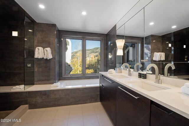 bathroom with tile patterned floors, vanity, a mountain view, and tiled tub