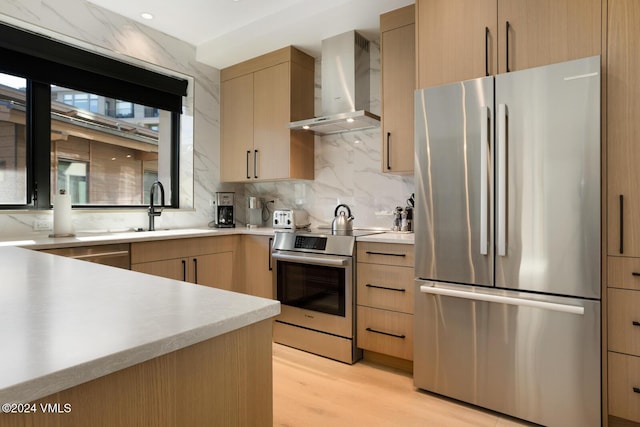 kitchen featuring wall chimney exhaust hood, appliances with stainless steel finishes, tasteful backsplash, and light brown cabinets