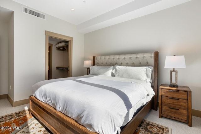 carpeted bedroom with a walk in closet and a closet