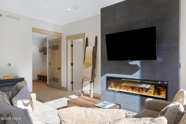 living room featuring a large fireplace and light hardwood / wood-style floors