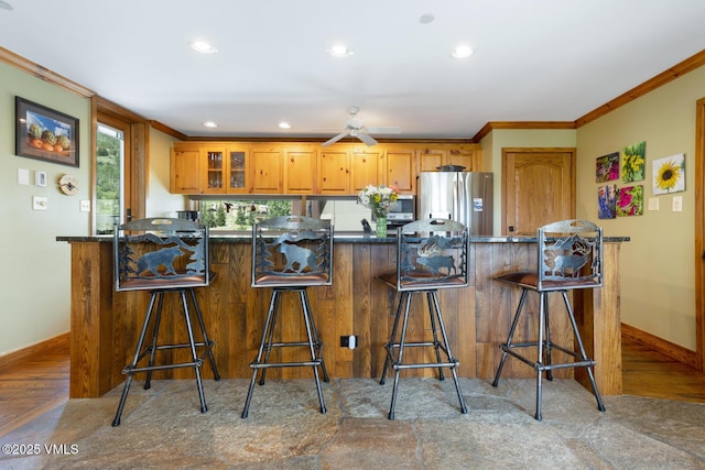 710 W Lionshead Cir Unit 501, Vail, CO 81657 - kitchen featuring stainless steel appliances, dark countertops, ornamental molding, recessed lighting, and a breakfast bar