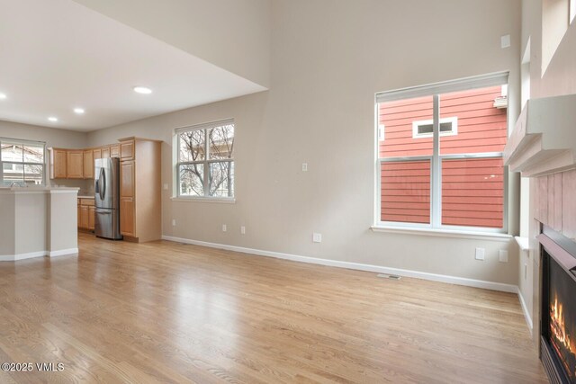 260 Longview Ave, Eagle, CO 81631 - unfurnished living room featuring a warm lit fireplace, recessed lighting, baseboards, and light wood-style floors