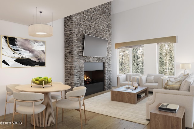 living room featuring a stone fireplace, hardwood / wood-style floors, and a high ceiling