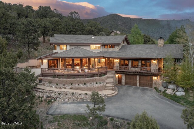 147 Salt Creek Ct, Eagle, CO 81631 - view of front of property with an attached garage, stairs, a chimney, driveway, and stone siding