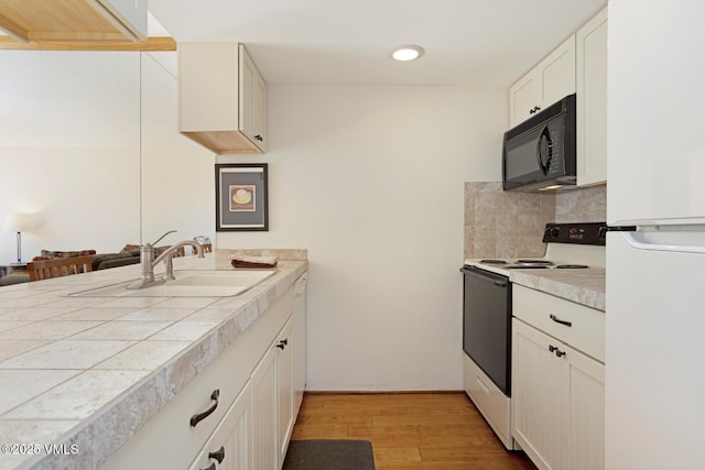 4506 Spruce Way Unit 2, Vail, CO 81657 - kitchen featuring white appliances, light wood finished floors, backsplash, white cabinets, and recessed lighting