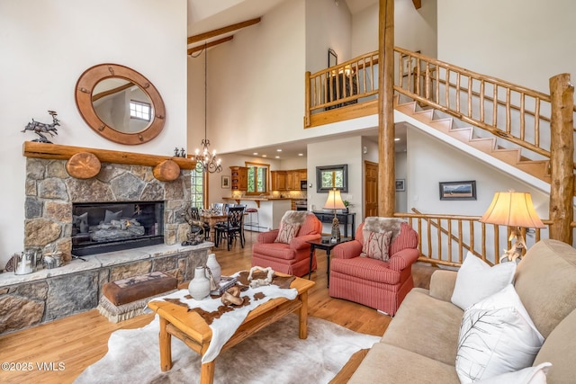 25 Cottage Cir, Edwards, CO 81632 - living area featuring wood finished floors, high vaulted ceiling, stairway, a stone fireplace, and a chandelier