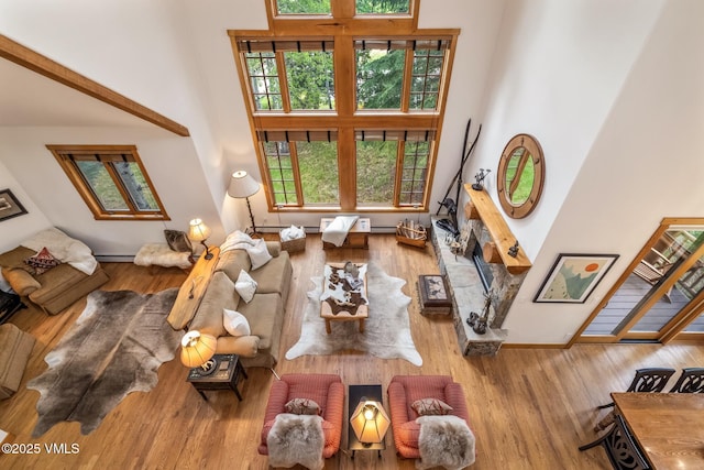 25 Cottage Cir, Edwards, CO 81632 - living area with a towering ceiling, wood finished floors, a baseboard heating unit, and baseboards