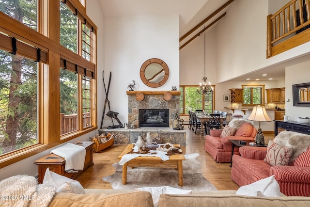 25 Cottage Cir, Edwards, CO 81632 - living area with a towering ceiling, healthy amount of natural light, a stone fireplace, a chandelier, and light wood finished floors