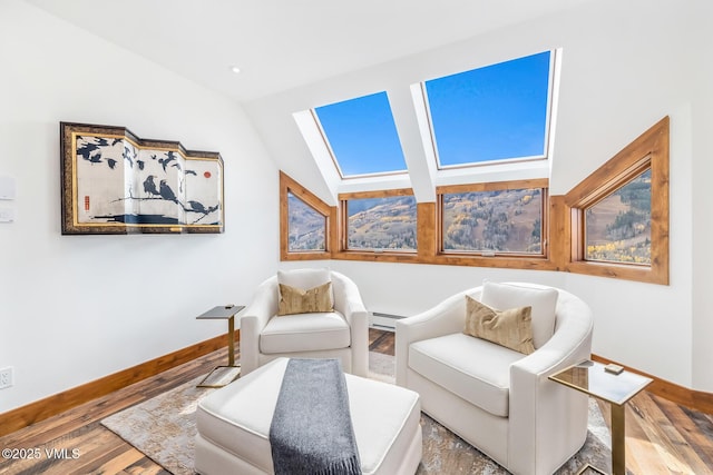 living area with hardwood / wood-style floors, baseboard heating, and lofted ceiling with skylight