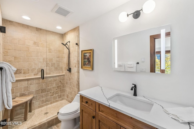 bathroom featuring vanity, an enclosed shower, and toilet