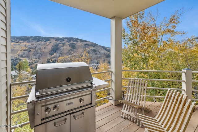 wooden deck featuring a mountain view and area for grilling