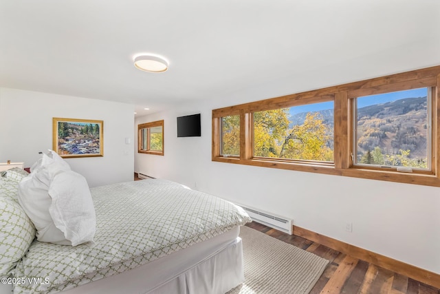 bedroom with baseboard heating and wood-type flooring