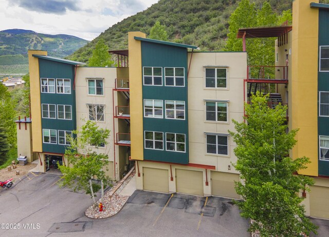 511 Metcalf Rd Unit I27, Avon, CO 81620 - view of property featuring a mountain view, an attached garage, and driveway