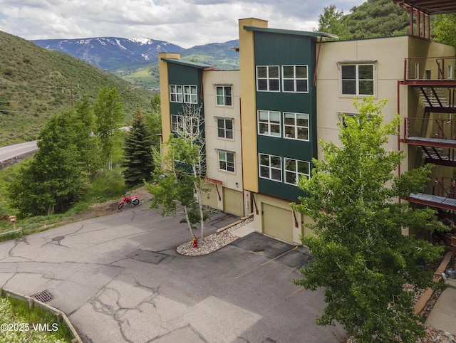 511 Metcalf Rd Unit I27, Avon, CO 81620 - view of building exterior with asphalt driveway, a garage, and a mountain view