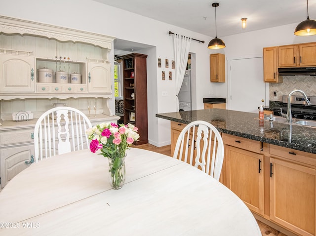 511 Metcalf Rd Unit I27, Avon, CO 81620 - dining space featuring stacked washer and clothes dryer, light wood finished floors, and baseboards