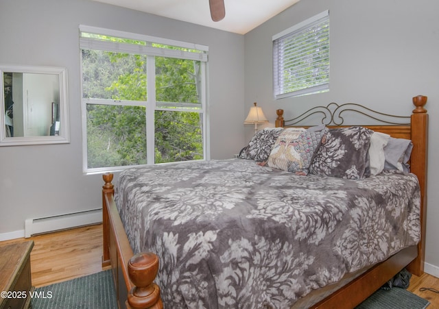 511 Metcalf Rd Unit I27, Avon, CO 81620 - bedroom featuring a baseboard radiator, wood finished floors, baseboards, and a ceiling fan