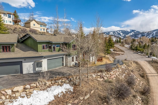 2960 June Creek Trl Unit A, Avon, CO 81620 - view of side of property featuring driveway, a mountain view, roof with shingles, and an attached garage
