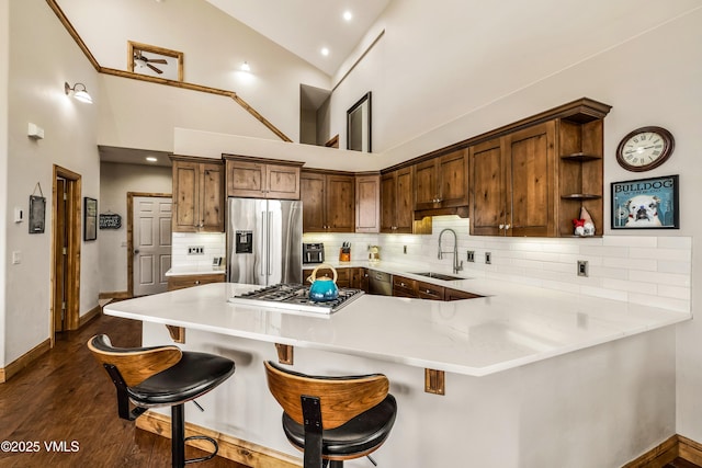 2960 June Creek Trl Unit A, Avon, CO 81620 - kitchen with appliances with stainless steel finishes, decorative backsplash, a peninsula, open shelves, and a breakfast bar area