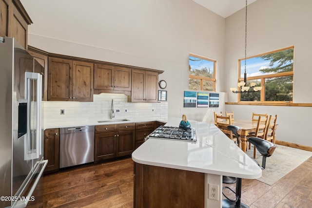 2960 June Creek Trl Unit A, Avon, CO 81620 - kitchen with stainless steel appliances, dark wood-style floors, light countertops, a towering ceiling, and decorative backsplash