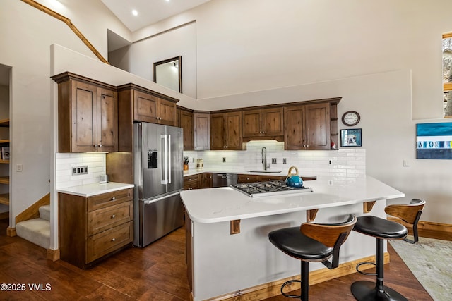 2960 June Creek Trl Unit A, Avon, CO 81620 - kitchen featuring stainless steel appliances, a high ceiling, dark wood-style flooring, light countertops, and a kitchen breakfast bar