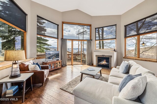 2960 June Creek Trl Unit A, Avon, CO 81620 - living room with wood-type flooring, a tiled fireplace, and vaulted ceiling