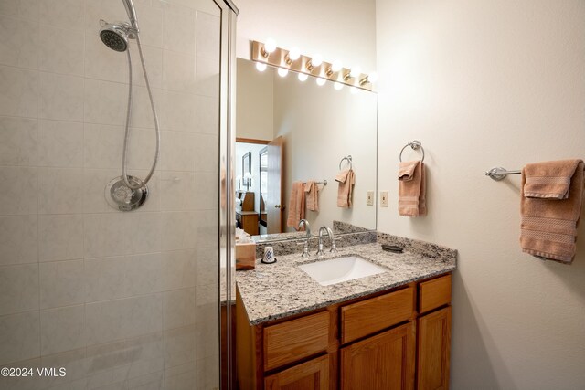 bathroom with vanity and a tile shower